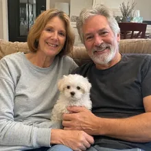 Anja en Peter op de bank met pup Milo op schoot